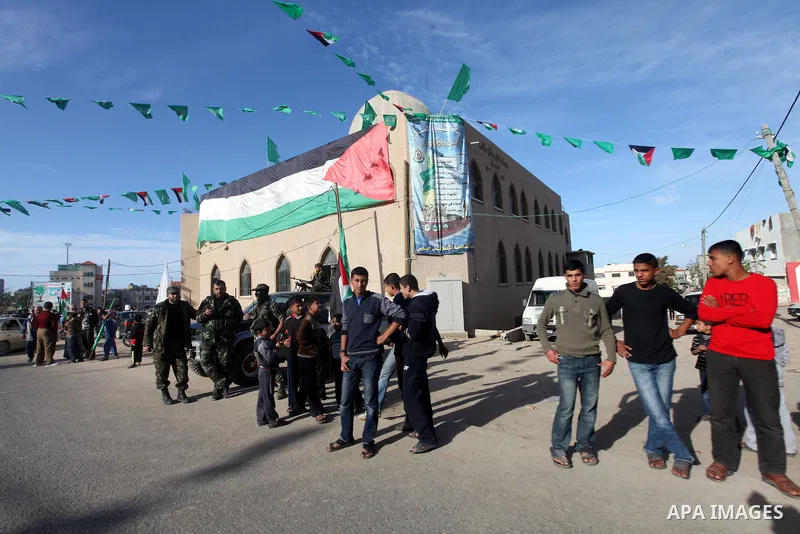 Palestinians stand waiting for the Islamist movement's exiled politburo chief Khaled Meshaal, during the preparations for his arrival to the Gaza Strip to celebrate its 25th anniversary on December 7, 2012. Meshaal is ma...
