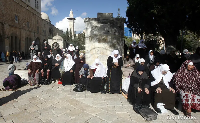 Palestinian women worshippers pray outside the Dome of the Rock at al-Aqsa mosque compound, Islam's third holiest site, on December 7, 2012, in the old city of Jerusalem. Photo by Mahfouz Abu Turk