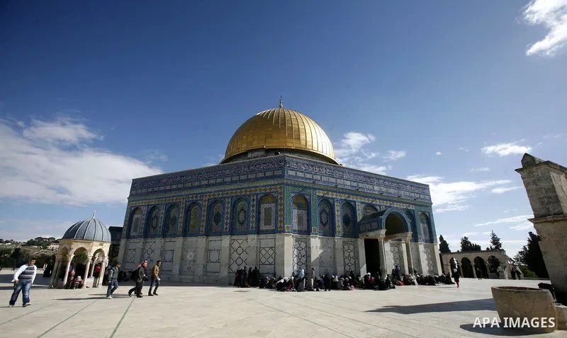 Palestinians walk in front of the dome of the rock and Al Aqsa mosque in the old city of Jerusalem on December 7, 2012. Photo by Mahfouz Abu Turk