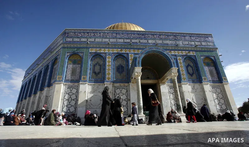 Palestinians walk in front of the dome of the rock and Al Aqsa mosque in the old city of Jerusalem on December 7, 2012. Photo by Mahfouz Abu Turk