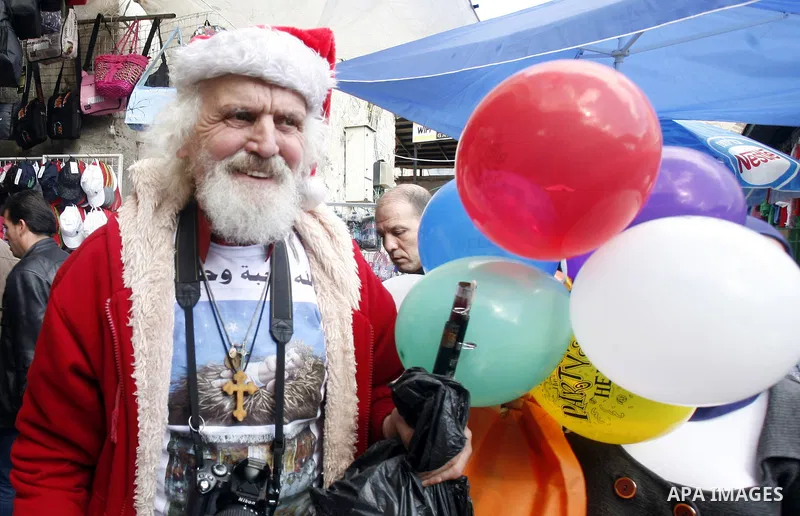 A Palestinian man dressed-up in a Santa Claus costume walks in Jerusalem's Old City market on December 7, 2012. Photo by Mahfouz Abu Turk