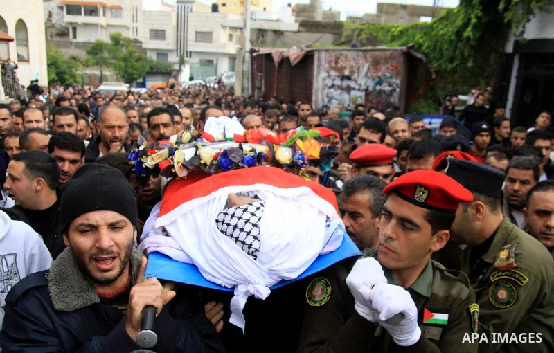 Palestinian security forces carry the body of 37-year-old Hatem Shadid, who was shot dead by members of the Israeli internal security agency after ramming their car and attacking them with an axe in the West Bank area of...