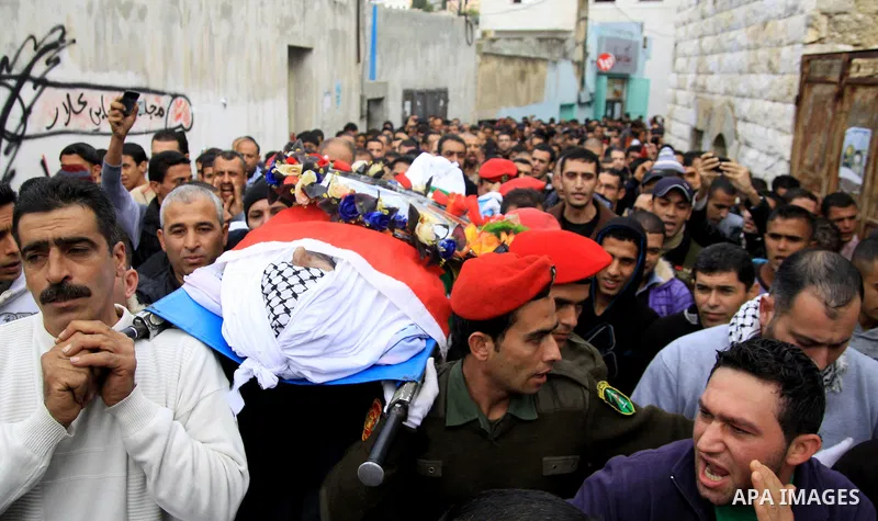 Palestinians carry the body of Hatem Shadid, who was shot dead by Israeli officers on December 3, during his funeral in the West Bank village of Alar, near Tulkarem December 7, 2012. Shadid, rammed an Israeli army jeep c...