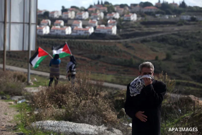 A Palestinian protester runs from tear gas during clashes following a demonstration against the expropriation of Palestinian land by Israel in the West Bank village of Nabi Saleh on December 7, 2012. Photo by Issam Rimaw...