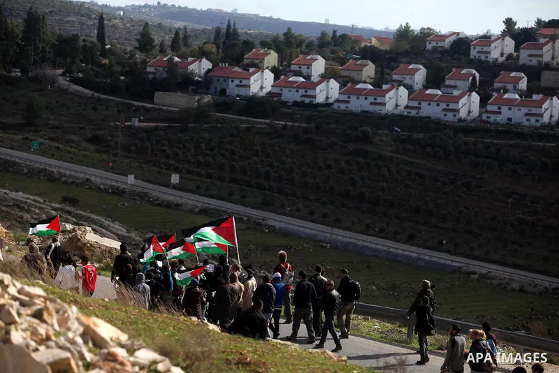 Palestinian Youth holds a poster of Hatem Shadid (L) who killed by Israeli soldier (R), during clashes following a demonstration against the expropriation of Palestinian land by Israel in the West Bank village of Nabi Sa...