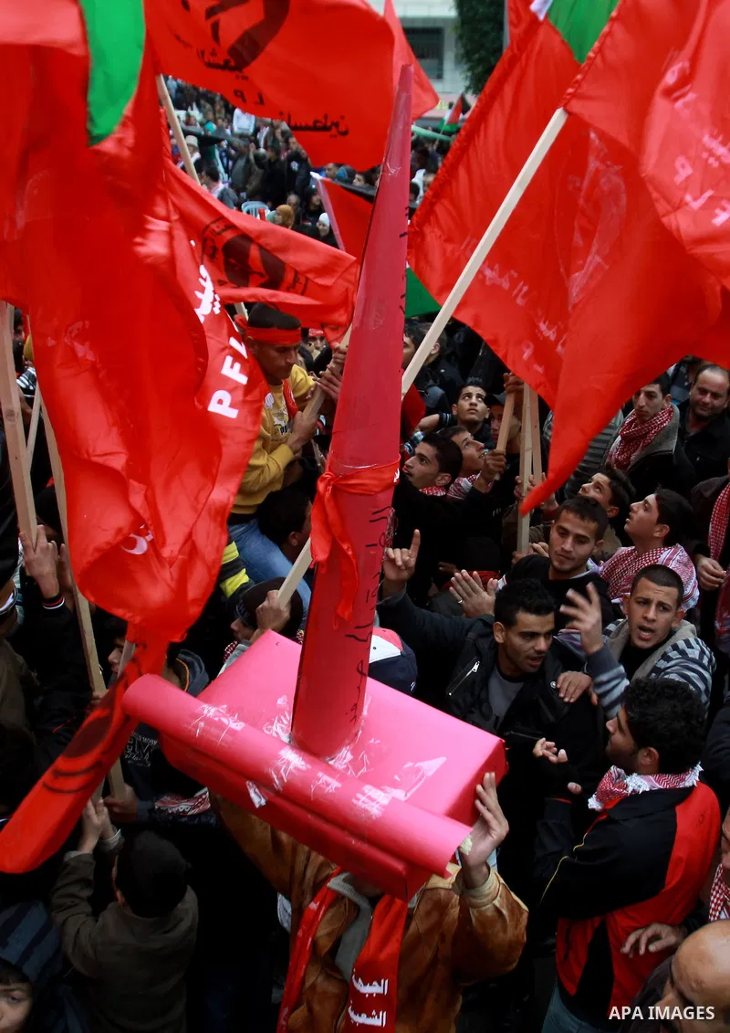 Supporters of the Popular Front for the Liberation of Palestine (PFLP) carry the party flag during a rally to mark the 45th anniversary of the establishment of the PFLP in the West Bank city of Nablus on December 8, 2012...