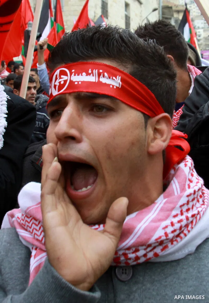 Supporters of the Popular Front for the Liberation of Palestine (PFLP) carry the party flag during a rally to mark the 45th anniversary of the establishment of the PFLP in the West Bank city of Nablus on December 8, 2012...