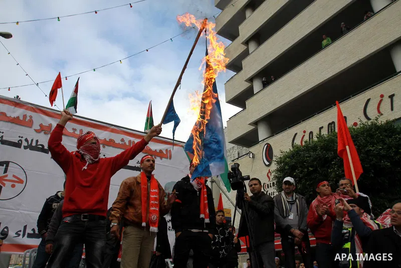 A Palestinian protester burn israeli flag, and hold up banners and portraits during a rally to mark the 45th anniversary of the establishment of the PFLP in the West Bank city of Nablus on December 8, 2012. Photo by Neda...
