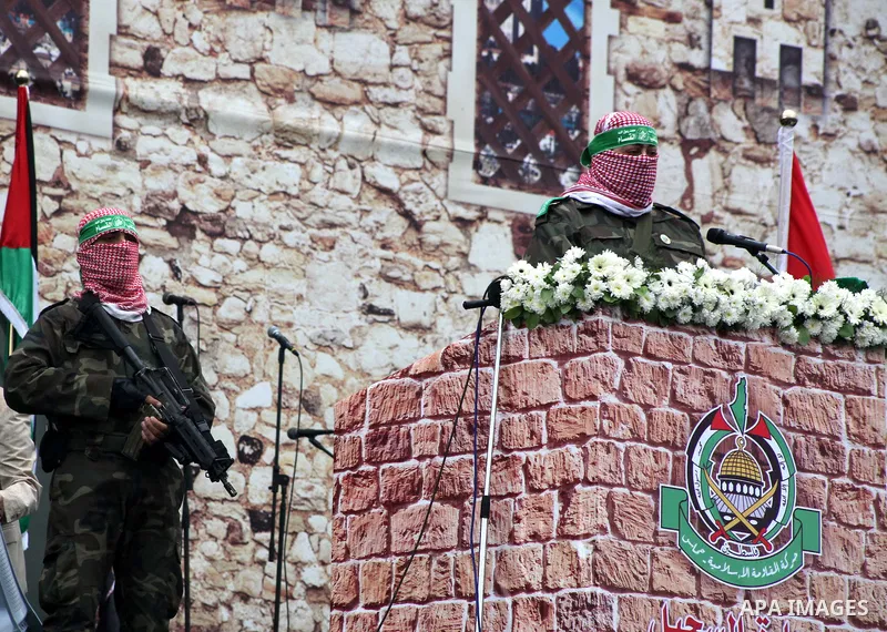 A Palestinian member of the Ezzedine al-Qassam brigades, the armed wing of Hamas, speaks during a Hamas rally marking the 25th anniversary of the Islamist movement's founding in Gaza City on December 8, 2012. Hamas chief...