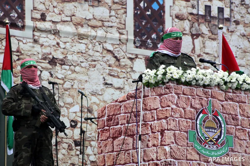 A Palestinian member of the Ezzedine al-Qassam brigades, the armed wing of Hamas, speaks during a Hamas rally marking the 25th anniversary of the Islamist movement's founding in Gaza City on December 8, 2012. Hamas chief...