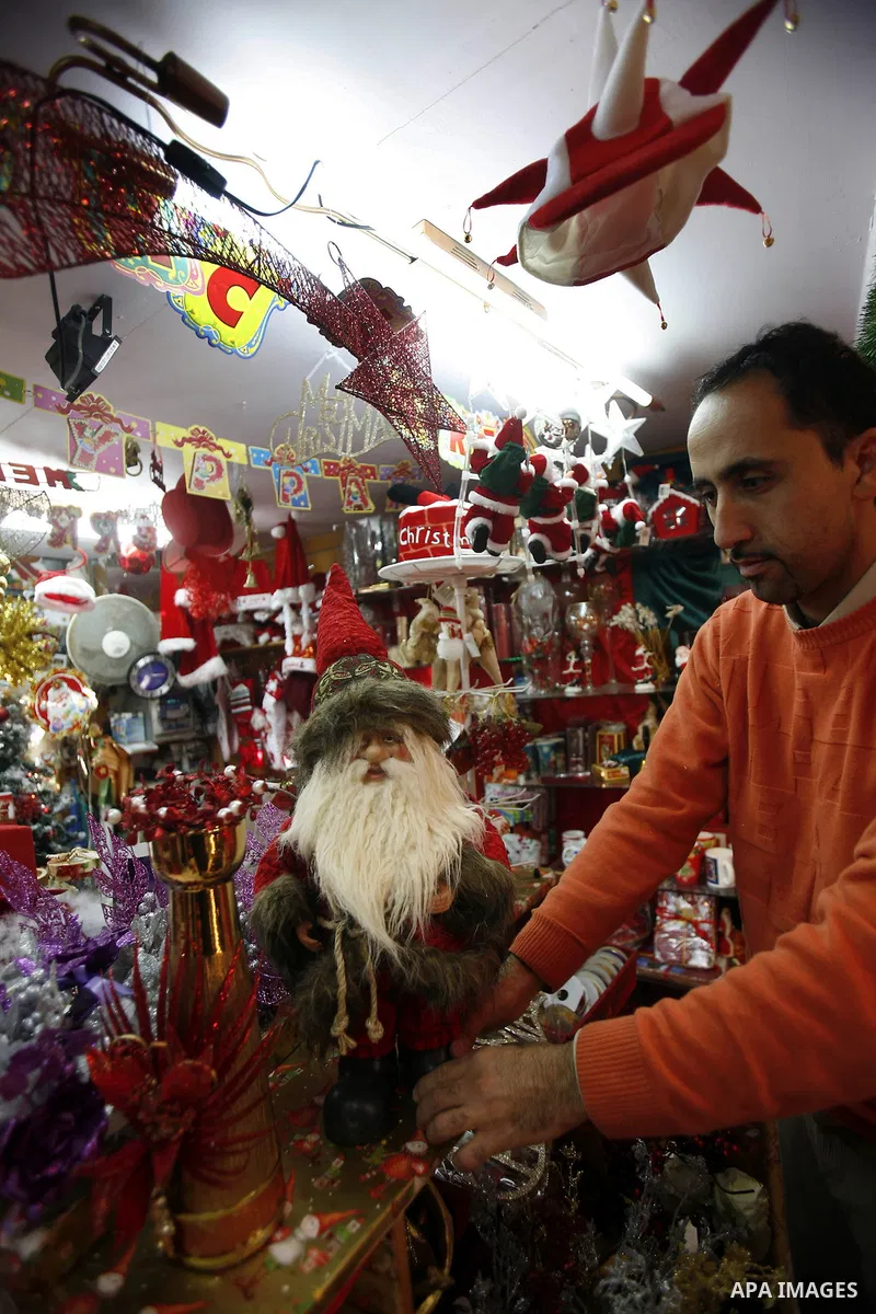 A Palestinian vendor decorates his store for the upcoming Christmas festivities in Jerusalem's old city, December 9, 2012. Christmas is celebrated across the globe on December 25 every year. Photo by Mahfouz Abu Turk