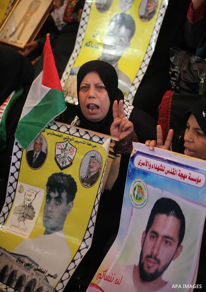 Palestinian women hold pictures of their prisoner relatives in Israeli jails as they gather in a weekly activity calling for their liberty at the Red Cross headquarters in Gaza City on December 10, 2012. Photo by Ashraf...