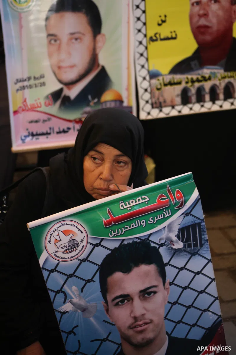 Palestinian women hold pictures of their prisoner relatives in Israeli jails as they gather in a weekly activity calling for their liberty at the Red Cross headquarters in Gaza City on December 10, 2012. Photo by Ashraf...