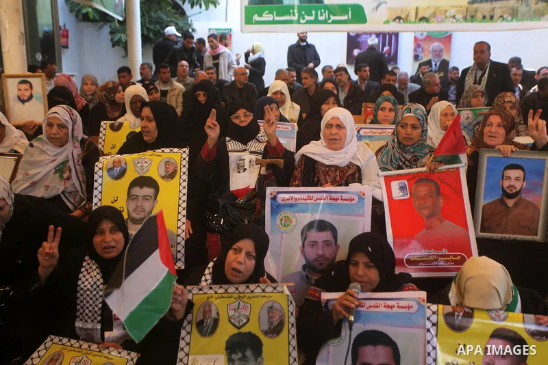 Palestinian women hold pictures of their prisoner relatives in Israeli jails as they gather in a weekly activity calling for their liberty at the Red Cross headquarters in Gaza City on December 10, 2012. Photo by Ashraf...