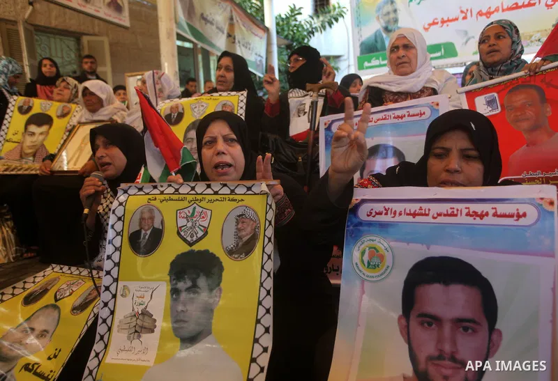 Palestinian women hold pictures of their prisoner relatives in Israeli jails as they gather in a weekly activity calling for their liberty at the Red Cross headquarters in Gaza City on December 10, 2012. Photo by Ashraf...