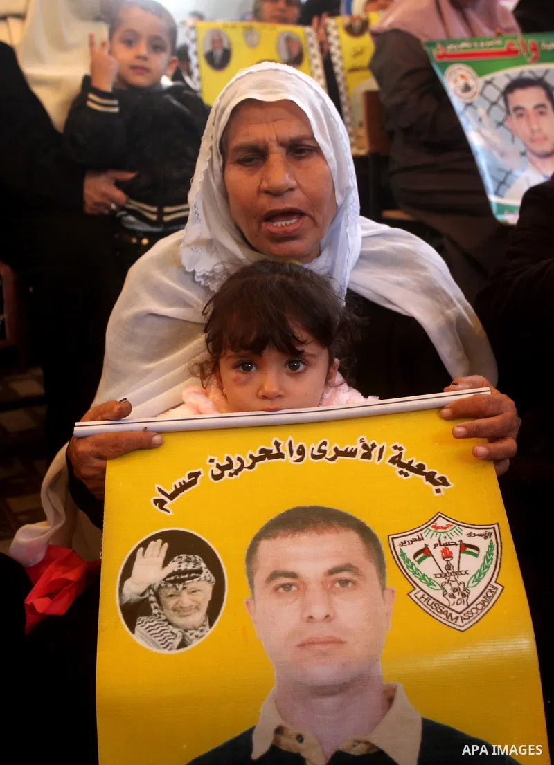 Palestinian women hold pictures of their prisoner relatives in Israeli jails as they gather in a weekly activity calling for their liberty at the Red Cross headquarters in Gaza City on December 10, 2012. Photo by Ashraf...