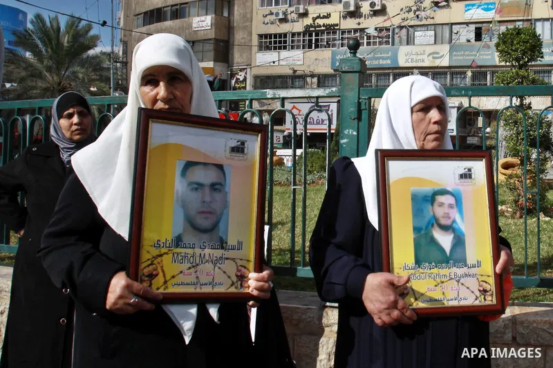 Palestinian women hold pictures of their prisoner relatives in Israeli jails as they gather in a weekly activity calling for their liberty in the West Bank City of Nablus on December 10, 2012. Photo by Nedal Eshtayah