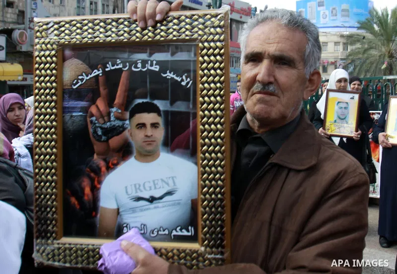 Palestinians hold pictures of their prisoner relatives in Israeli jails as they gather in a weekly activity calling for their liberty in the West Bank City of Nablus on December 10, 2012. Photo by Nedal Eshtayah