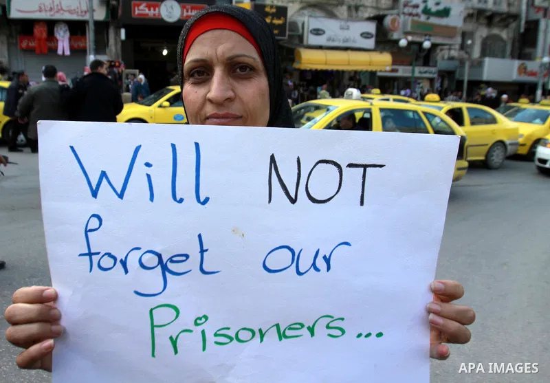 Palestinians hold pictures of their prisoner relatives in Israeli jails as they gather in a weekly activity calling for their liberty in the West Bank City of Nablus on December 10, 2012. Photo by Nedal Eshtayah
