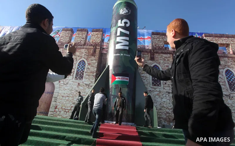 Palestinians take pictures in front of a gigantic model of a locally made M75 rocket in Gaza city, December 10, 2012. Hamas chief Khaled Meshaal arrived on December 7 during his first-ever visit to the Gaza Strip amid ti...