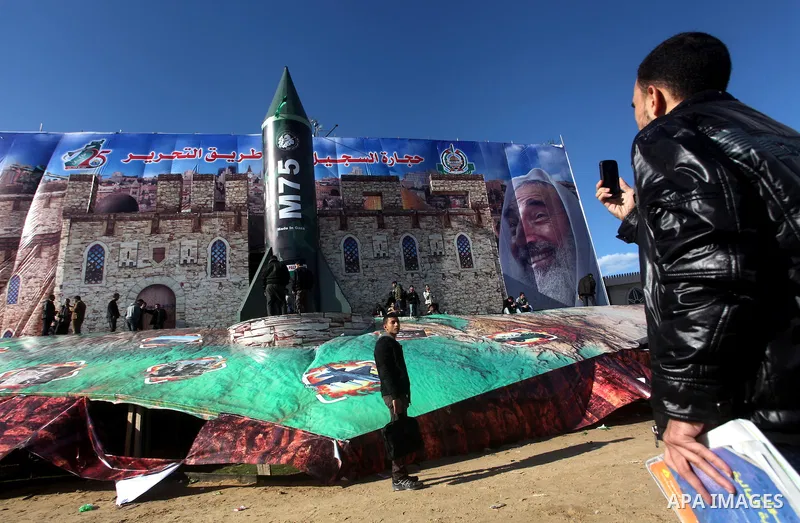 Palestinians take pictures in front of a gigantic model of a locally made M75 rocket in Gaza city, December 10, 2012. Hamas chief Khaled Meshaal arrived on December 7 during his first-ever visit to the Gaza Strip amid ti...