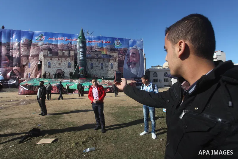 Palestinians take pictures in front of a gigantic model of a locally made M75 rocket in Gaza city, December 10, 2012. Hamas chief Khaled Meshaal arrived on December 7 during his first-ever visit to the Gaza Strip amid ti...