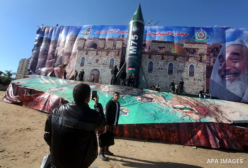 Palestinians take pictures in front of a gigantic model of a locally made M75 rocket in Gaza city, December 10, 2012. Hamas chief Khaled Meshaal arrived on December 7 during his first-ever visit to the Gaza Strip amid ti...
