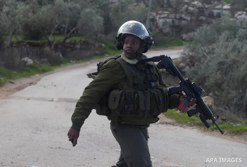 An Israeli soldier walks during an Israeli military incursion to village of Beit Liqya near the West Bank city of Ramallah, December 10, 2012. Photo by Issam Rimawi