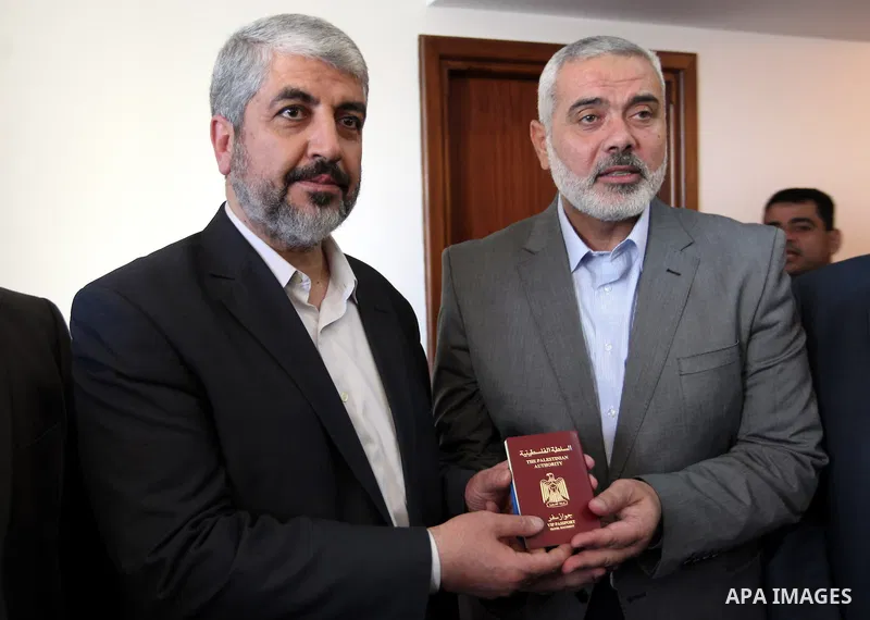 Palestinian Prime Minister in Gaza strip Ismail Haniyeh gives Hamas leader in exile Khaled Meshaal a diplomatic Palestinian passport, upon his departure from the Gaza Strip on December 10, 2012. Exiled Hamas chief Khaled...
