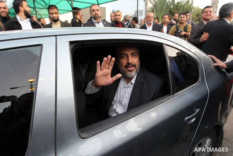 Hamas leader in exile Khaled Meshaal waves goodbye while sitting next to Palestinian Prime Minister in the Gaza Strip Ismail Haniya, upon his departure from the Gaza Strip on December 10, 2012 in Rafah, on the border wit...