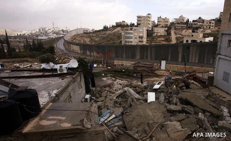 Member of the Palestinian Jabari family are seen close to the rubble of their house after it was demolished by Jerusalem municipality workers in the mostly Arab east Jerusalem neighborhood of al-Tur on December 11, 2012....
