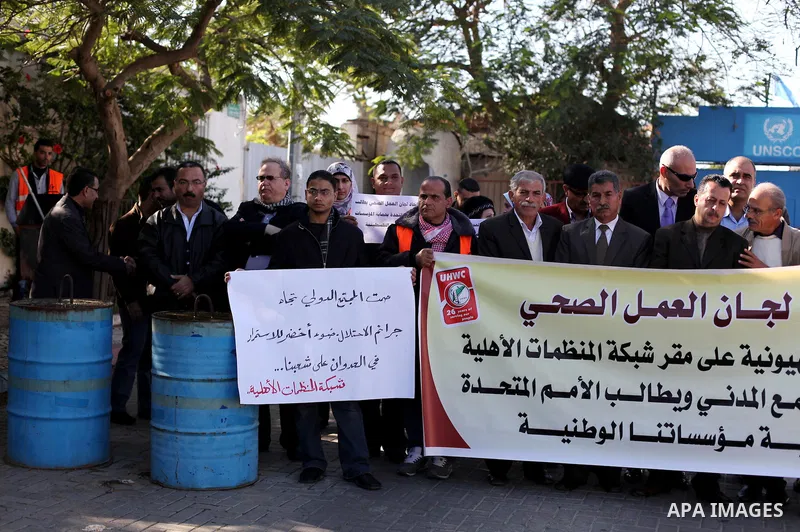 Palestinian employees of the Union of Health Work Committees protest to against Israeli attacks on the headquarters of the NGO network, in Gaza city, on Dec. 12, 2012. Photo by Ashraf Amra