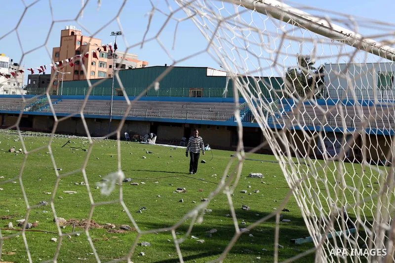 Palestinian security guards walk at a soccer stadium, which witnesses said was destroyed in an Israeli air strike during an eight-day conflict, in Gaza City December 4, 2012. Eight days of Israeli air strikes on Gaza and...