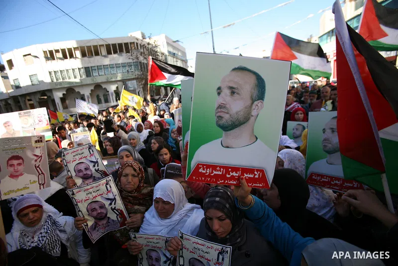 Protesters hold portraits of Samer Issawi and Ayman Sharwanah, Palestinian prisoners held in Israeli jails and on hunger strike, during a solidarity protest in the West Bank city of Hebron, December 12, 2012. Demonstrato...
