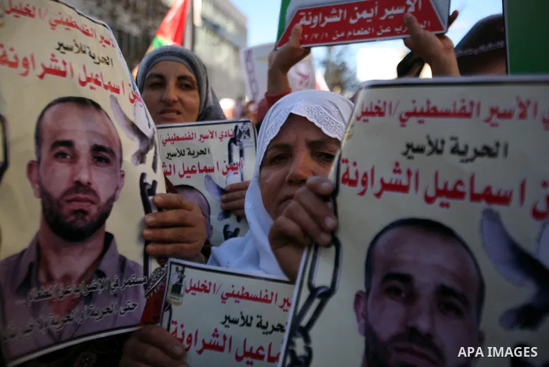 Protesters hold portraits of Samer Issawi and Ayman Sharwanah, Palestinian prisoners held in Israeli jails and on hunger strike, during a solidarity protest in the West Bank city of Hebron, December 12, 2012. Demonstrato...