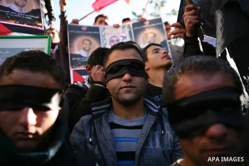 Protesters hold portraits of Samer Issawi and Ayman Sharwanah, Palestinian prisoners held in Israeli jails and on hunger strike, during a solidarity protest in the West Bank city of Hebron, December 12, 2012. Demonstrato...