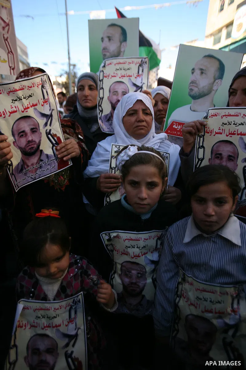 Protesters hold portraits of Samer Issawi and Ayman Sharwanah, Palestinian prisoners held in Israeli jails and on hunger strike, during a solidarity protest in the West Bank city of Hebron, December 12, 2012. Demonstrato...
