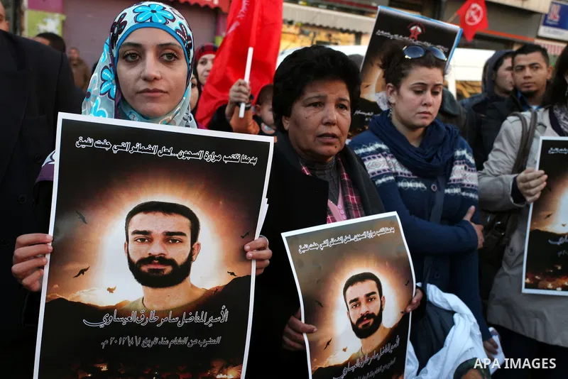 Protesters hold portraits of Samer Issawi, A Palestinian prisoner held in Israeli jail and on hunger strike, during a solidarity protest in the West Bank city of Ramallah, December 12, 2012. Demonstrators protested in so...