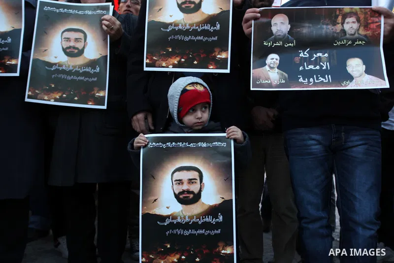 Protesters hold portraits of Samer Issawi, A Palestinian prisoner held in Israeli jail and on hunger strike, during a solidarity protest in the West Bank city of Ramallah, December 12, 2012. Demonstrators protested in so...