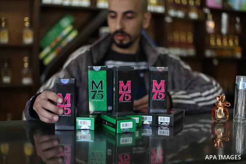 A Palestinian vendor displays perfume bottles called M75 at his shop in Gaza City December 12, 2012. The Gaza vendor said the new perfume symbolises the name of the home-made M75 rocket. Hamas' armed wing said they had f...
