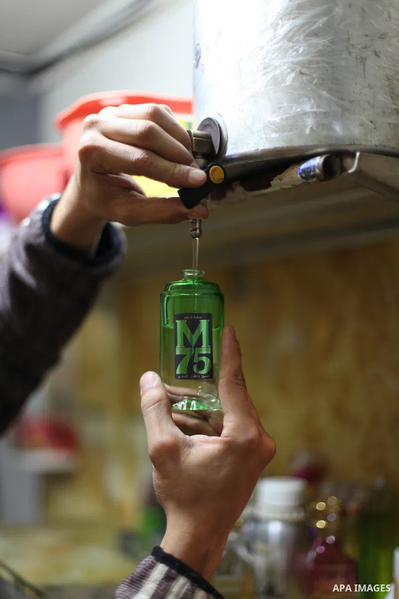A Palestinian vendor blends perfume in bottles called M75 at his shop in Gaza City December 12, 2012. The Gaza vendor said the new perfume symbolises the name of the home-made M75 rocket. Hamas' armed wing said they had...