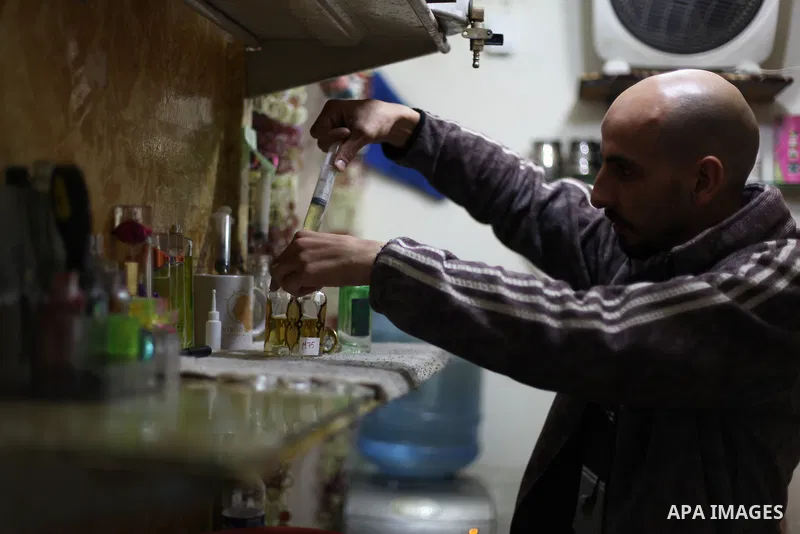 A Palestinian vendor blends perfume in bottles called M75 at his shop in Gaza City December 12, 2012. The Gaza vendor said the new perfume symbolises the name of the home-made M75 rocket. Hamas' armed wing said they had...