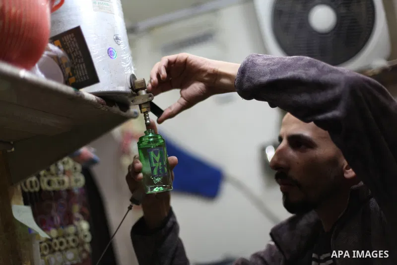 A Palestinian vendor blends perfume in bottles called M75 at his shop in Gaza City December 12, 2012. The Gaza vendor said the new perfume symbolises the name of the home-made M75 rocket. Hamas' armed wing said they had...