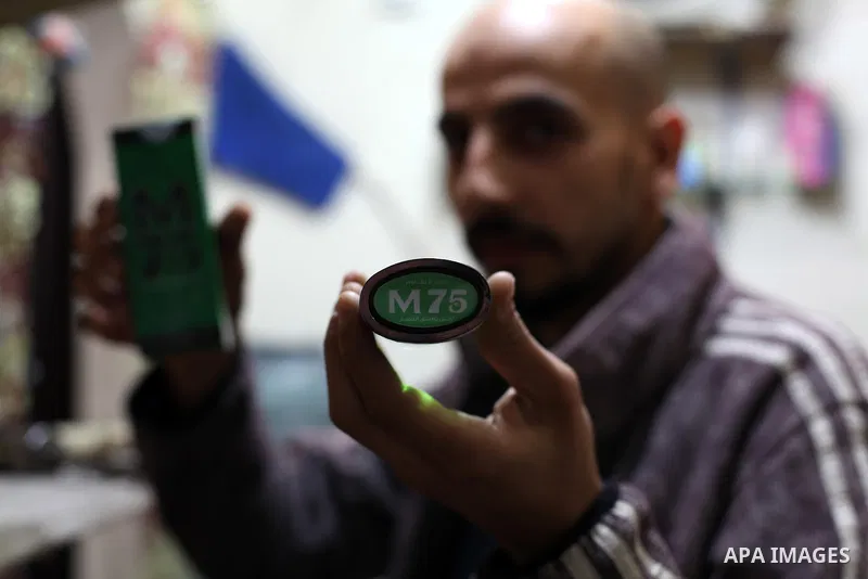 A Palestinian vendor blends perfume in bottles called M75 at his shop in Gaza City December 12, 2012. The Gaza vendor said the new perfume symbolises the name of the home-made M75 rocket. Hamas' armed wing said they had...