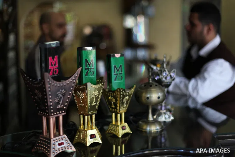 A Palestinian vendor displays perfume bottles called M75 at his shop in Gaza City December 12, 2012. The Gaza vendor said the new perfume symbolises the name of the home-made M75 rocket. Hamas' armed wing said they had f...