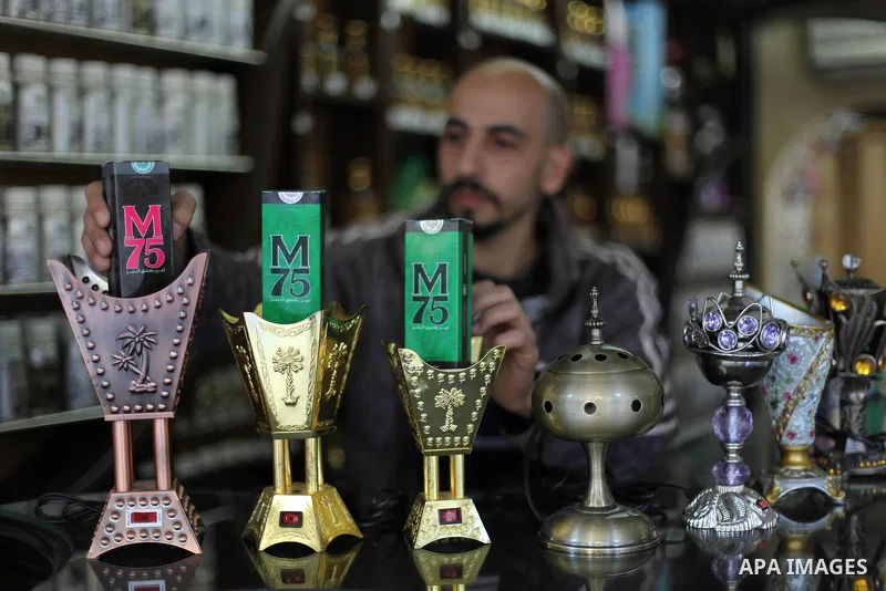 A Palestinian vendor displays perfume bottles called M75 at his shop in Gaza City December 12, 2012. The Gaza vendor said the new perfume symbolises the name of the home-made M75 rocket. Hamas' armed wing said they had f...