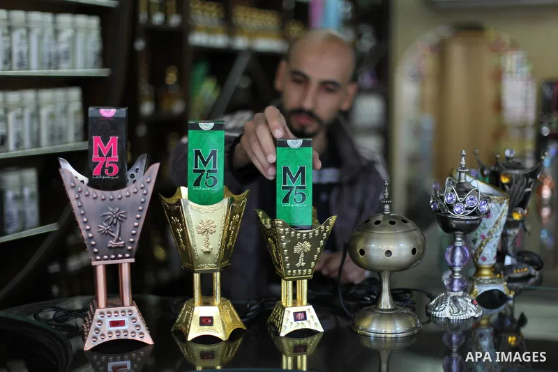 A Palestinian vendor displays perfume bottles called M75 at his shop in Gaza City December 12, 2012. The Gaza vendor said the new perfume symbolises the name of the home-made M75 rocket. Hamas' armed wing said they had f...