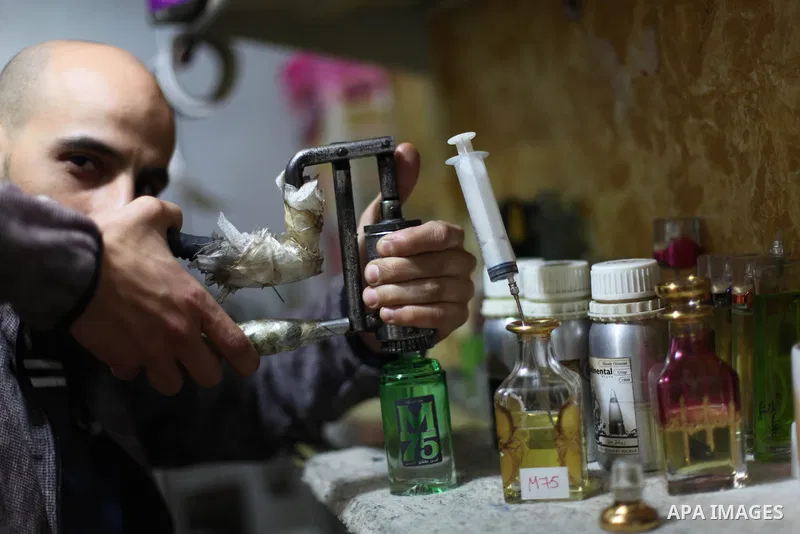 A Palestinian vendor blends perfume in bottles called M75 at his shop in Gaza City December 12, 2012. The Gaza vendor said the new perfume symbolises the name of the home-made M75 rocket. Hamas' armed wing said they had...