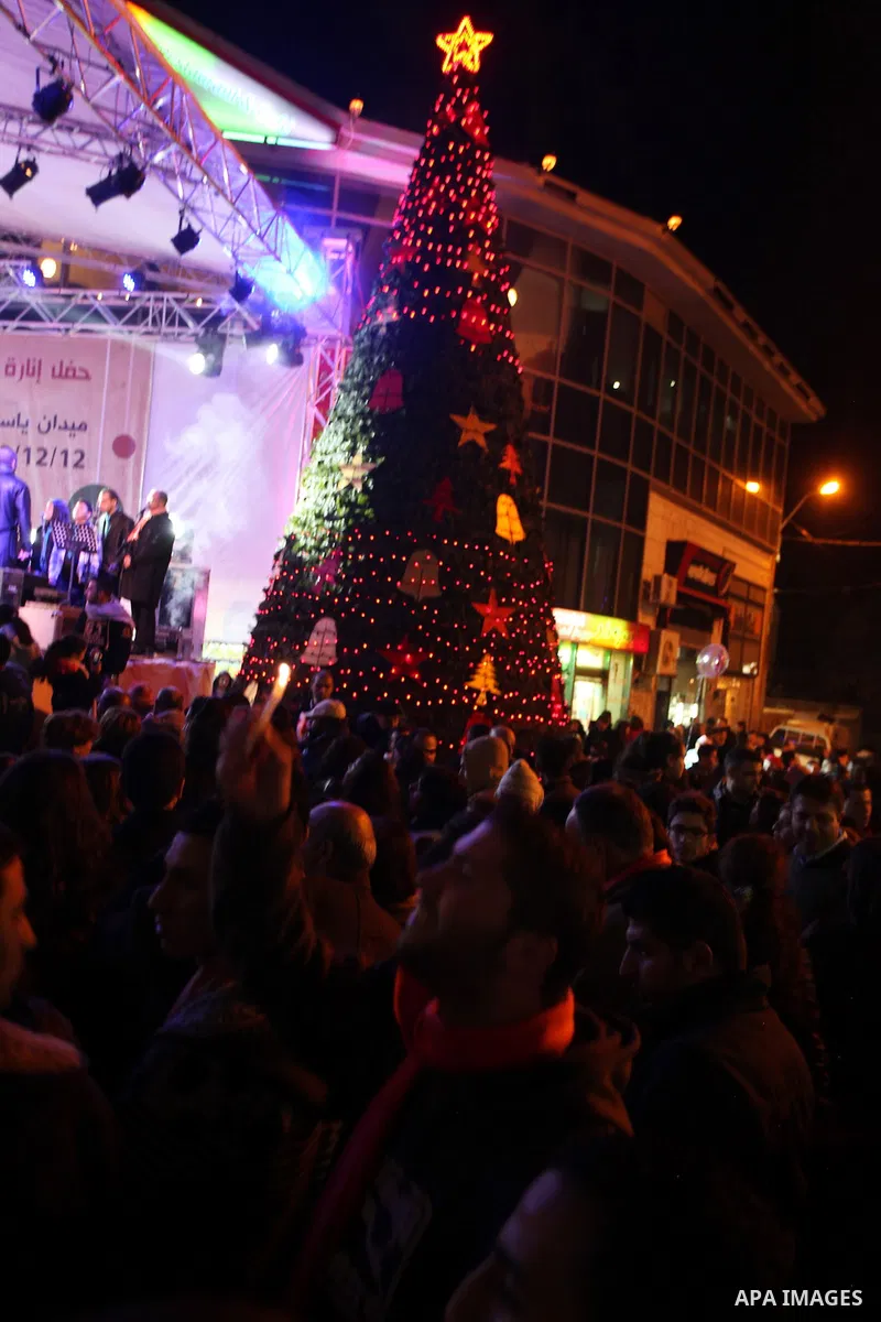 Palestinians participate a celebration by Palestinian Christians and Muslims to inaugurate Christmas' decorations in the West Bank city of Ramallah, on December 12, 2012. Photo by Issam Rimawi
