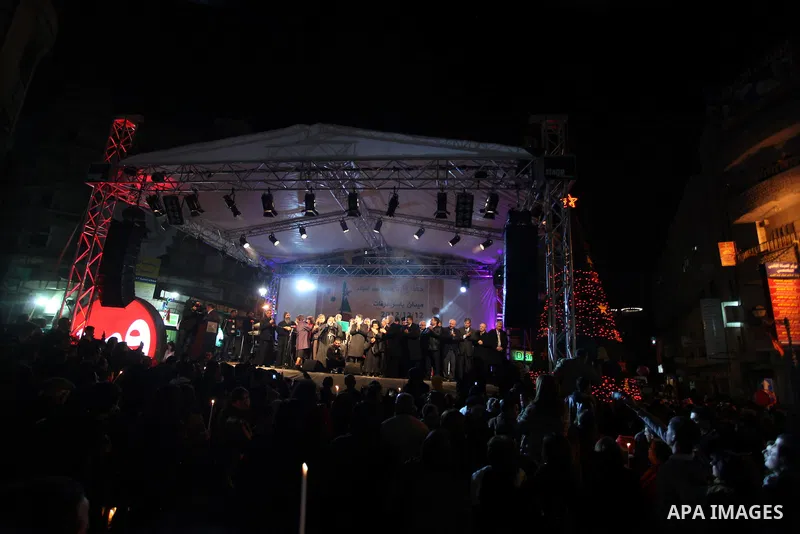 Palestinians participate a celebration by Palestinian Christians and Muslims to inaugurate Christmas' decorations in the West Bank city of Ramallah, on December 12, 2012. Photo by Issam Rimawi